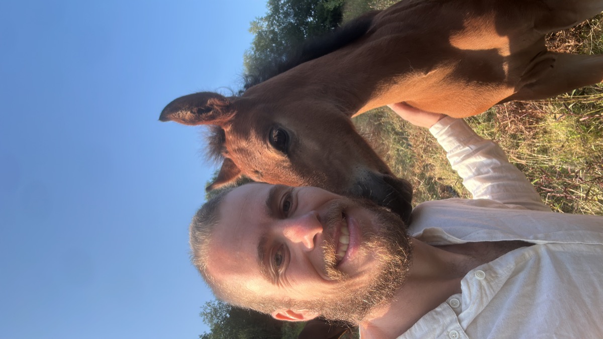 Robert, founder of Lewos, outdoors in Asturias with a young horse